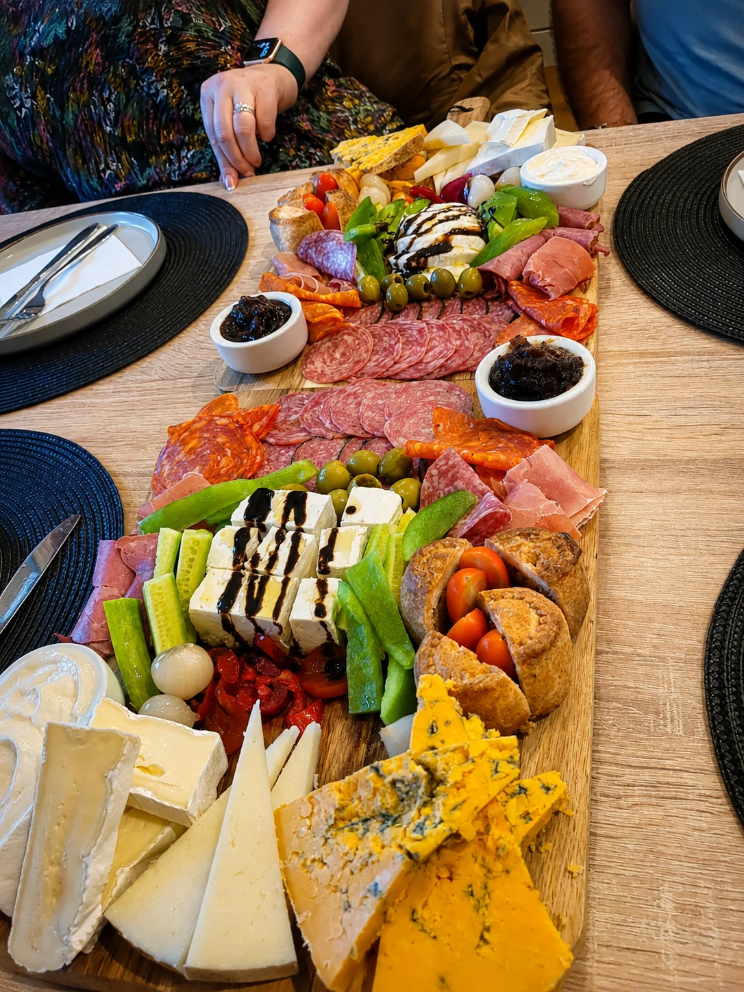 Long sharing board of meats, cheeses and vegetables