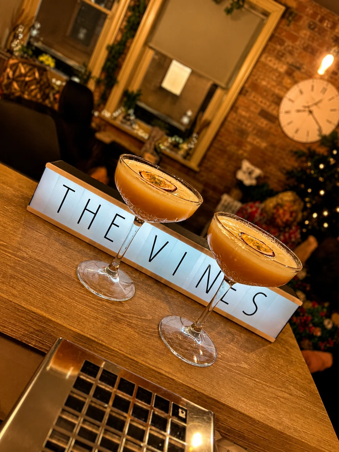 Two cocktails served beside The Vines sign